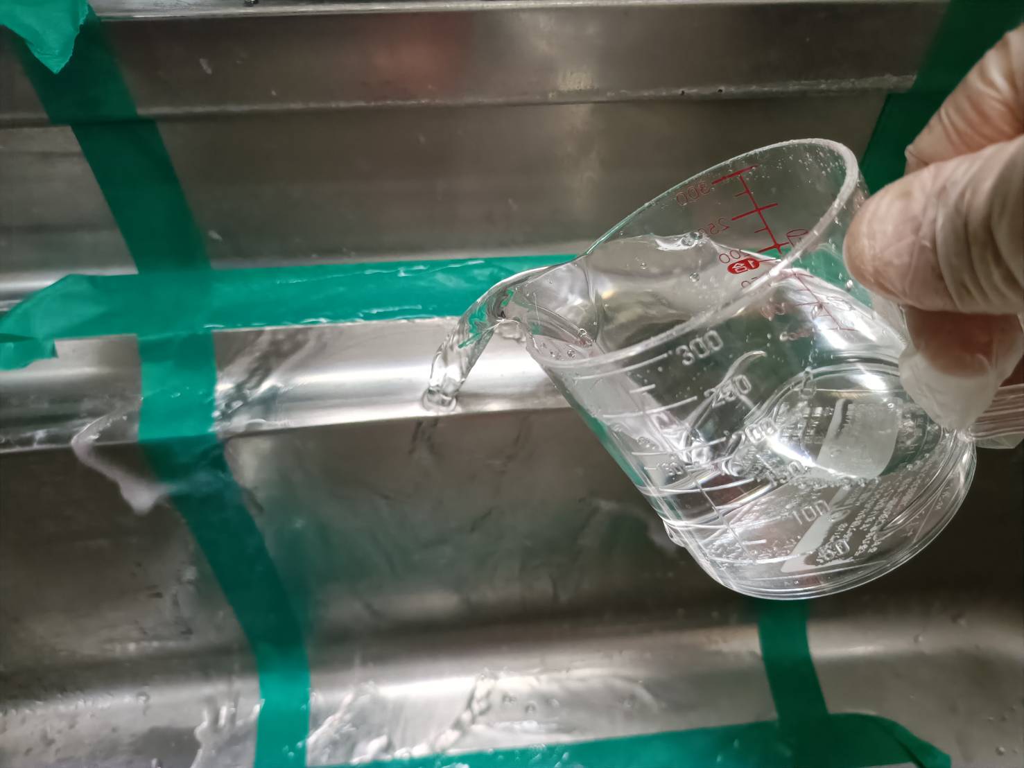 マジックリンで洗ったステンレスシンクを水ですすいでいる様子