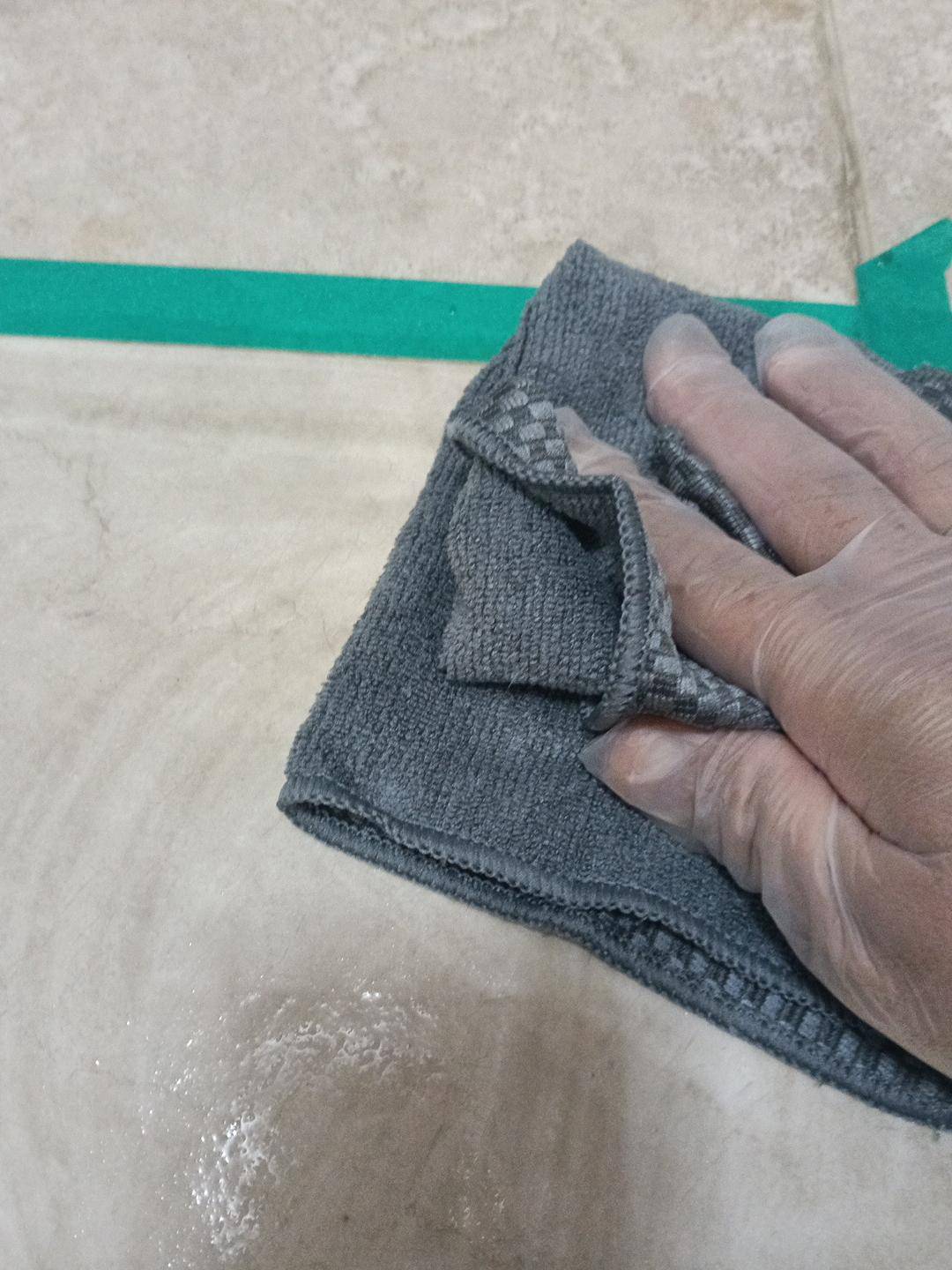 使い古したタオルで床の汚れと水分を拭き取っているところ