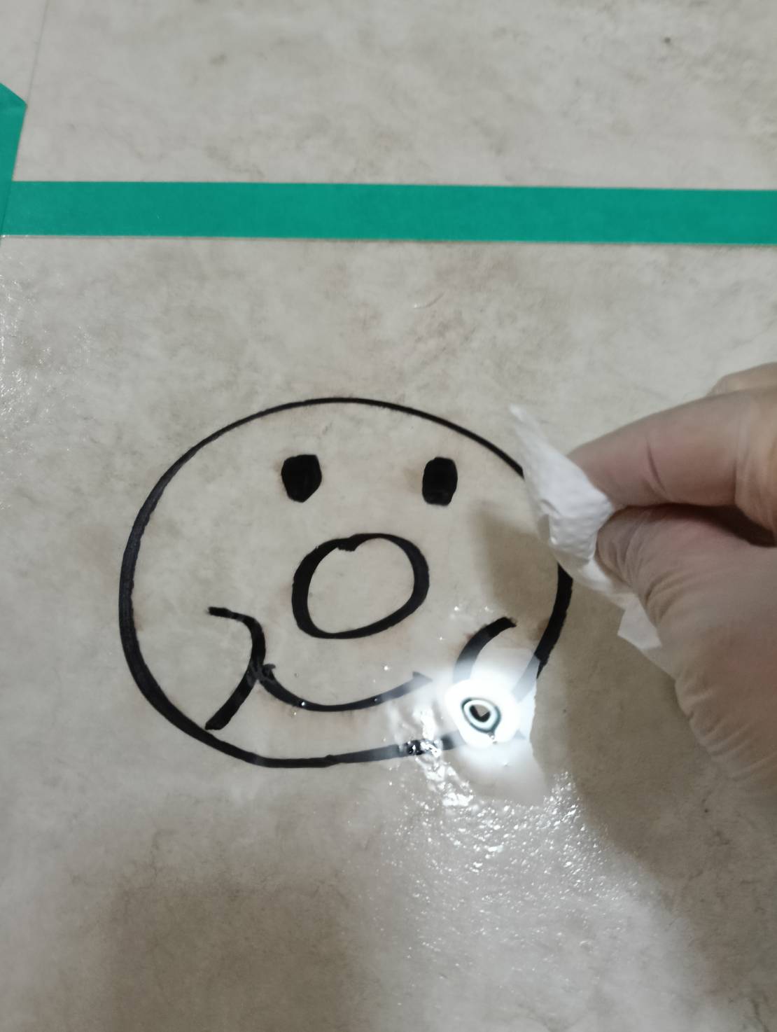 クリーナー30を塗布した油性マジックをキッチンペーパーで拭き取る様子