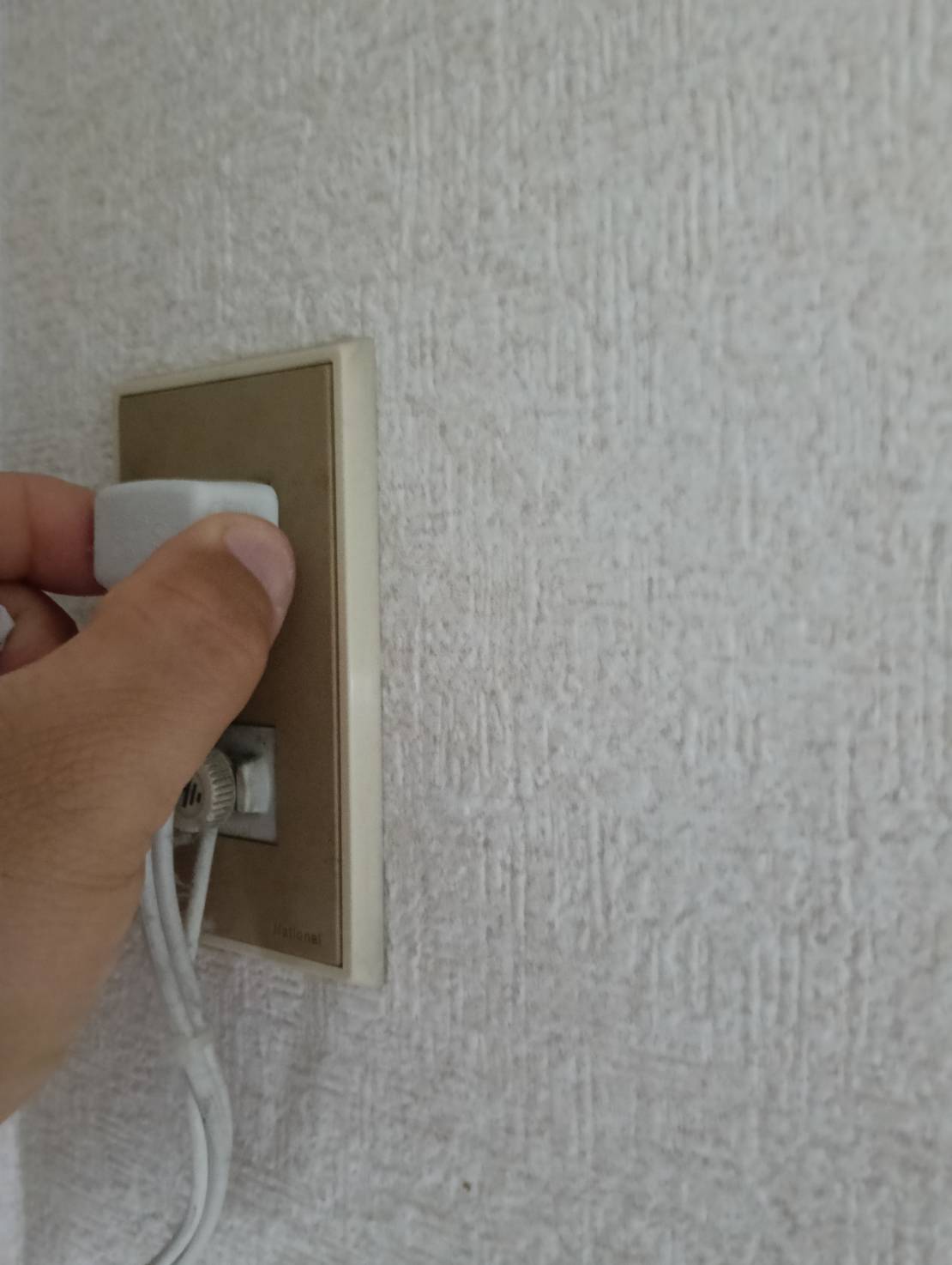 エアコン掃除前にコンセントから電源プラグを抜く様子